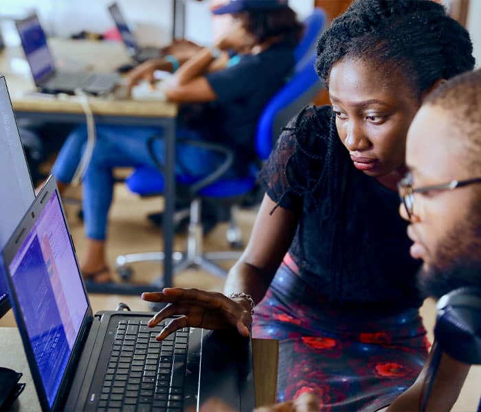 A man and a woman look at a computer screen together